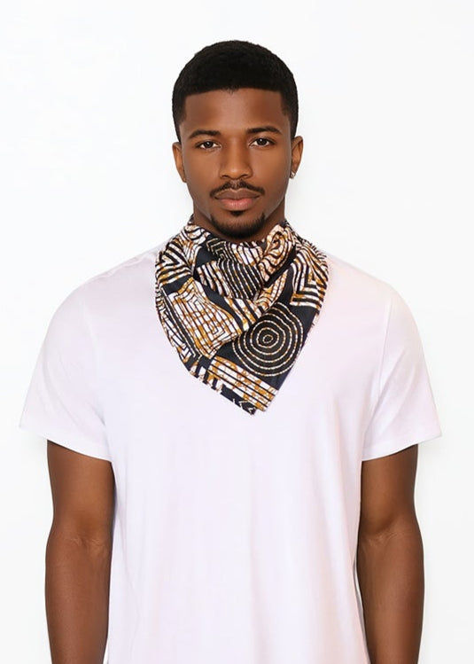 Man wearing a white t-shirt, dark jeans, and a patterned ankara African printed scarf on a white background