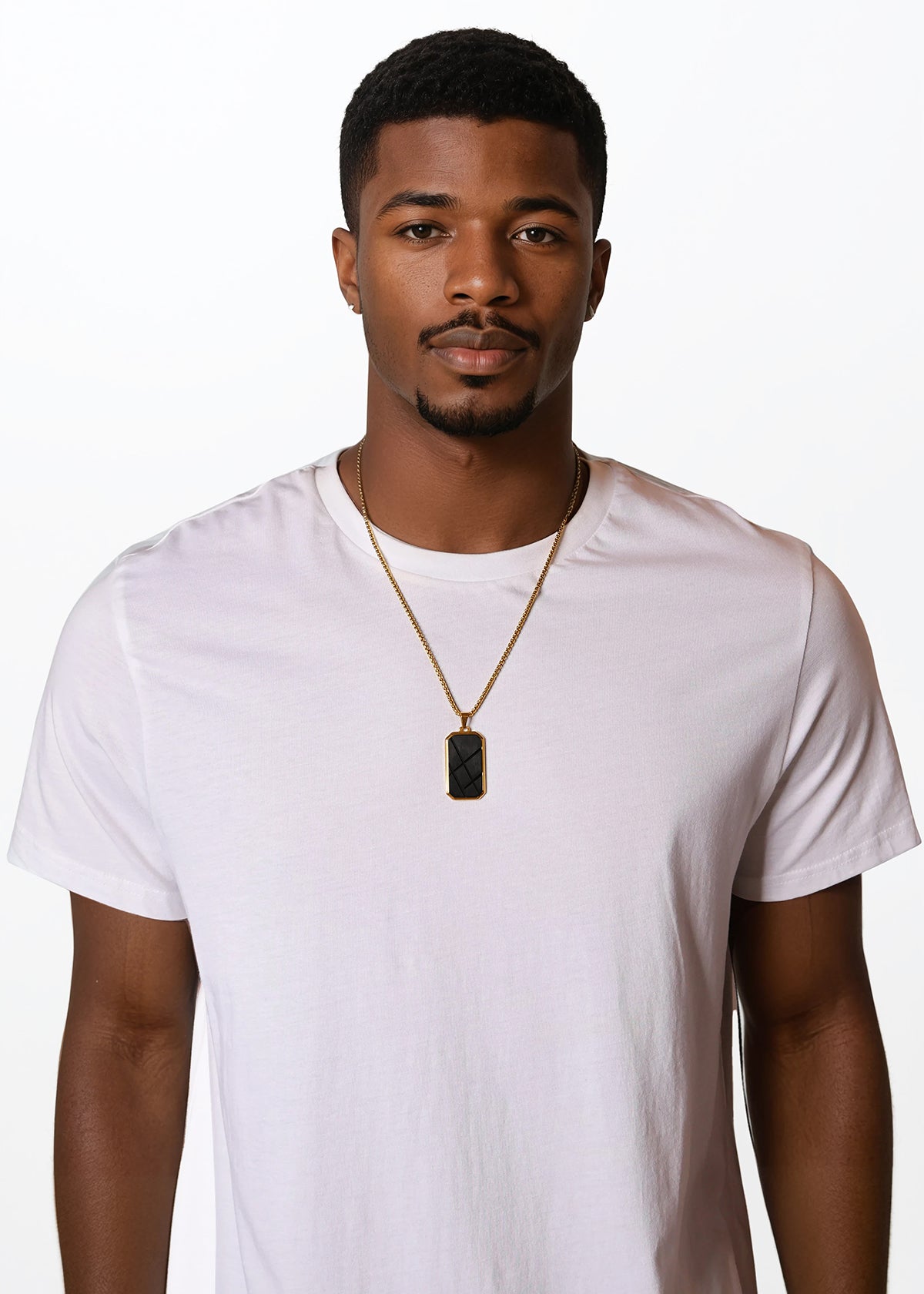 Man wearing a plain white t-shirt and gold necklace with a pendant on a white background