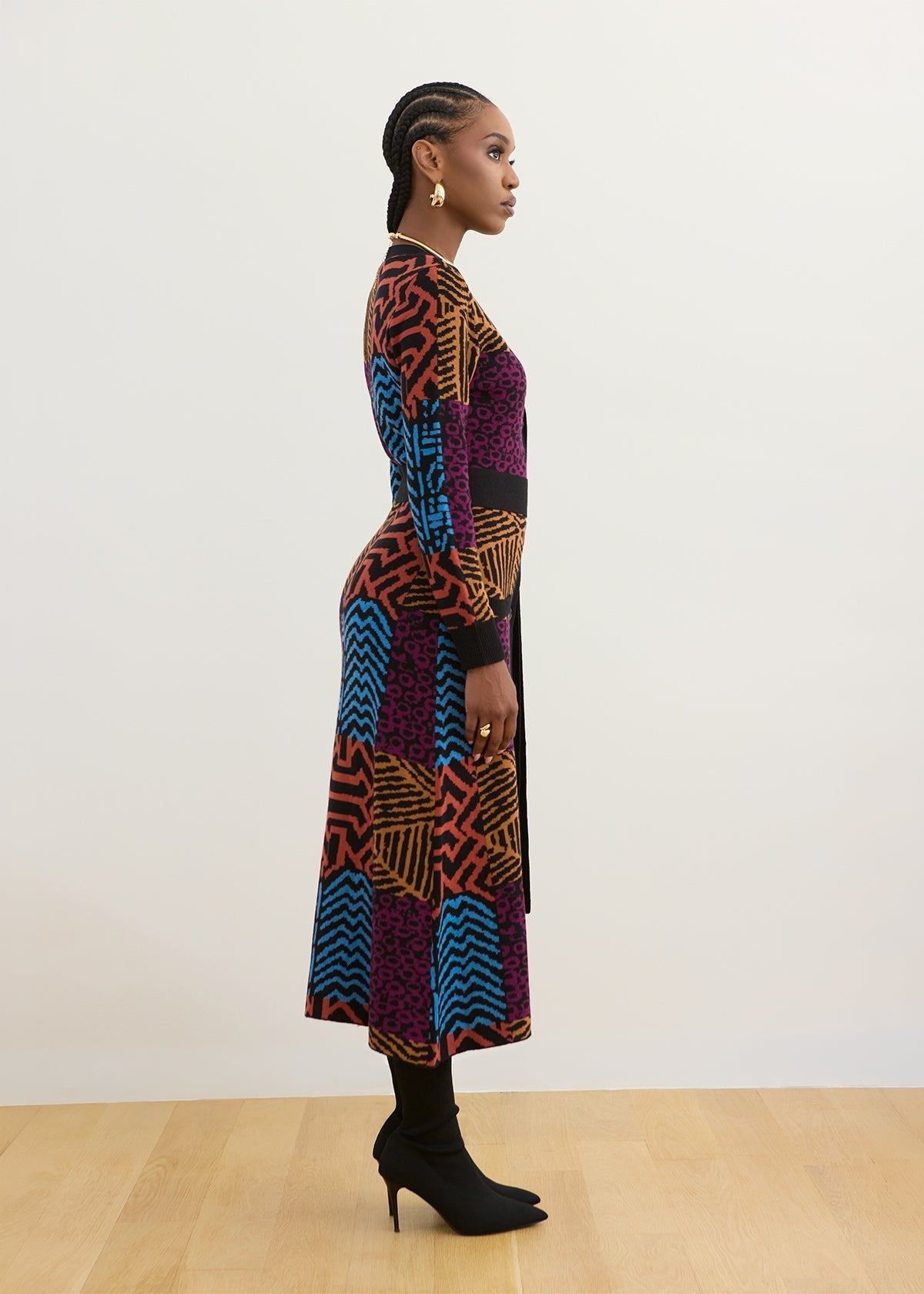 Side view of Aisha African print cardigan sweater showcasing its multicolor pattern on a model against an off-white wall