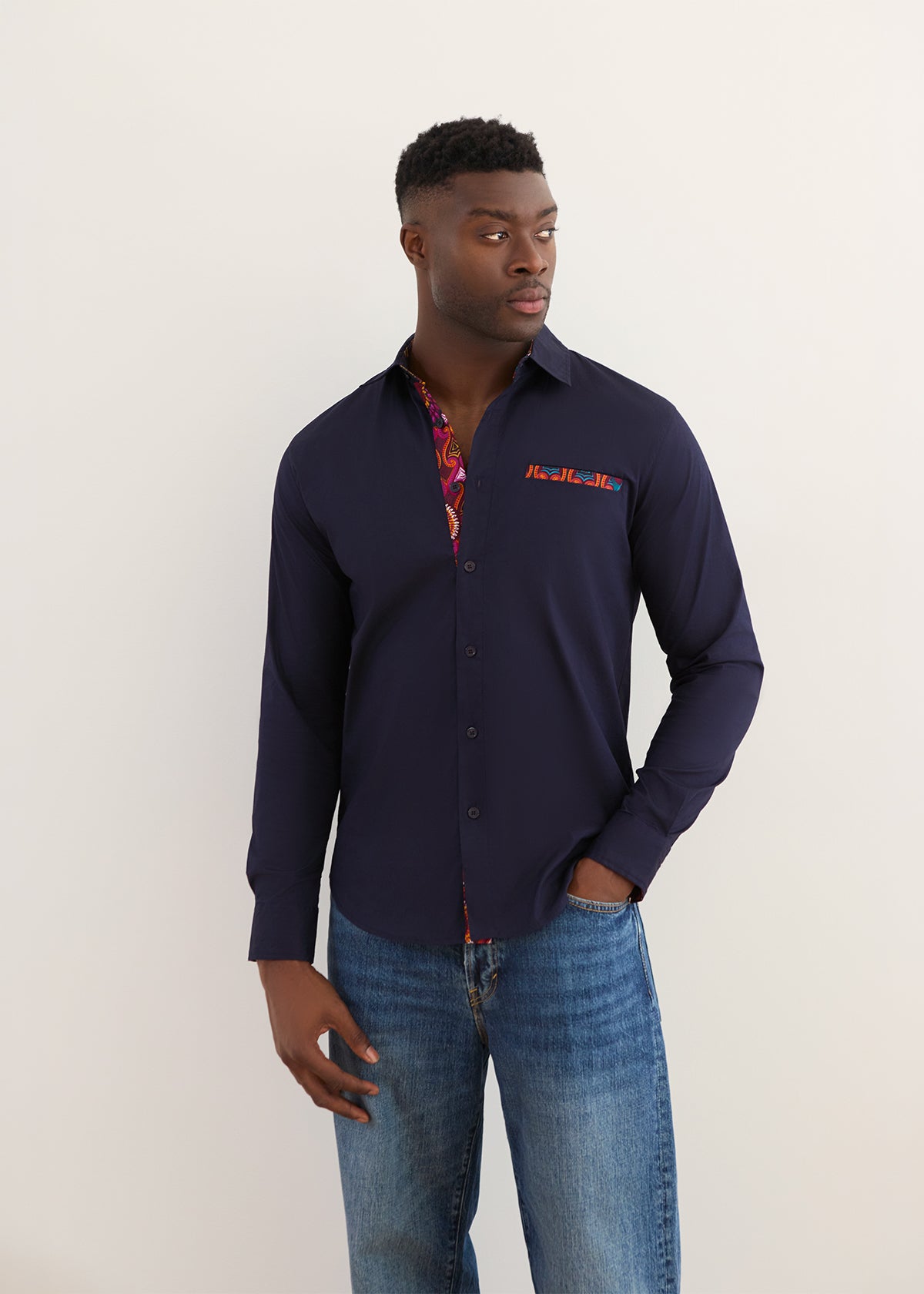 Front view of Naeem men’s navy African print button-up shirt with colorful patterned inner collar, off-white background