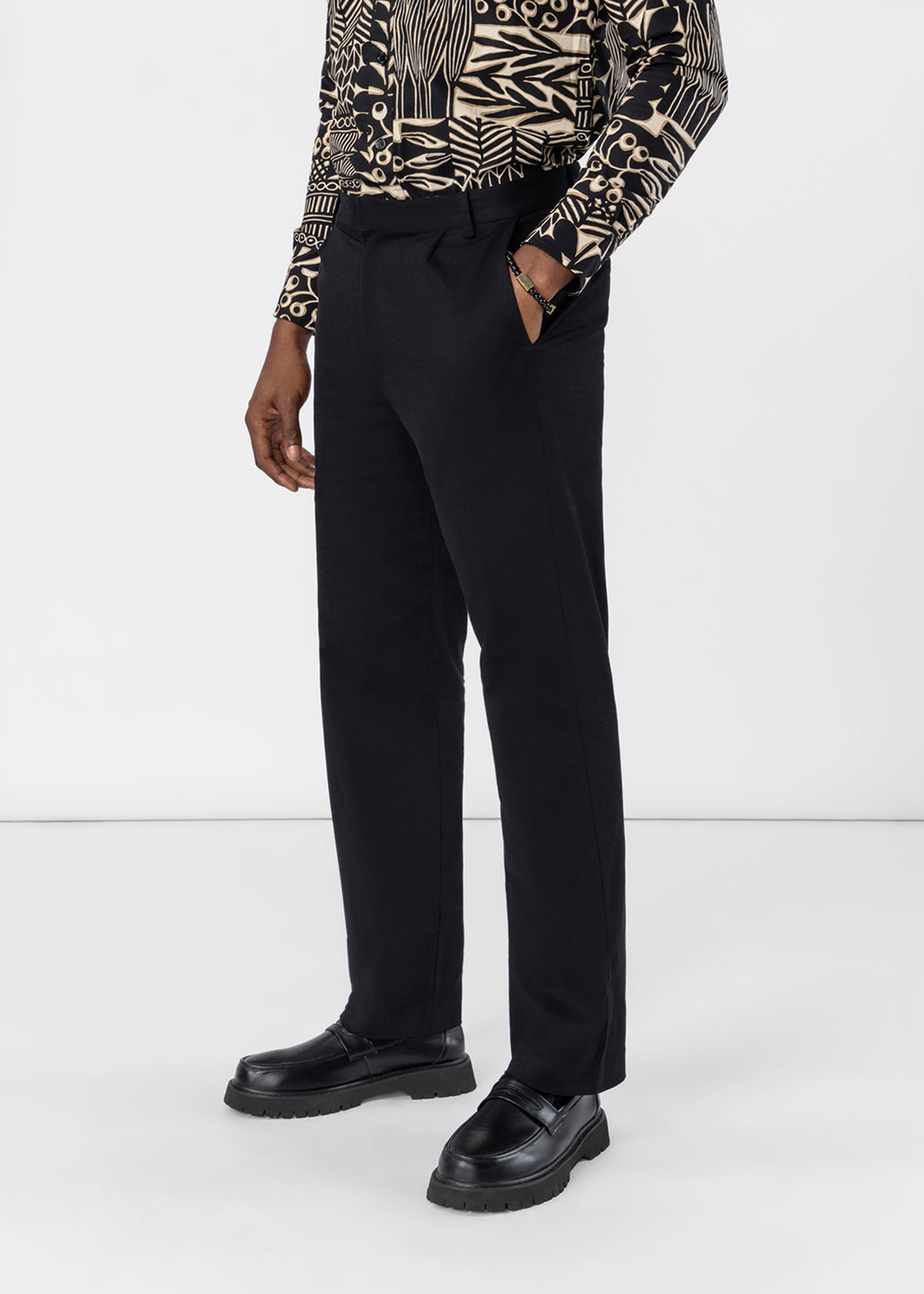 Front view of Tokunbo Men’s Pants showcasing black, full-length legs on a model against a light gray background