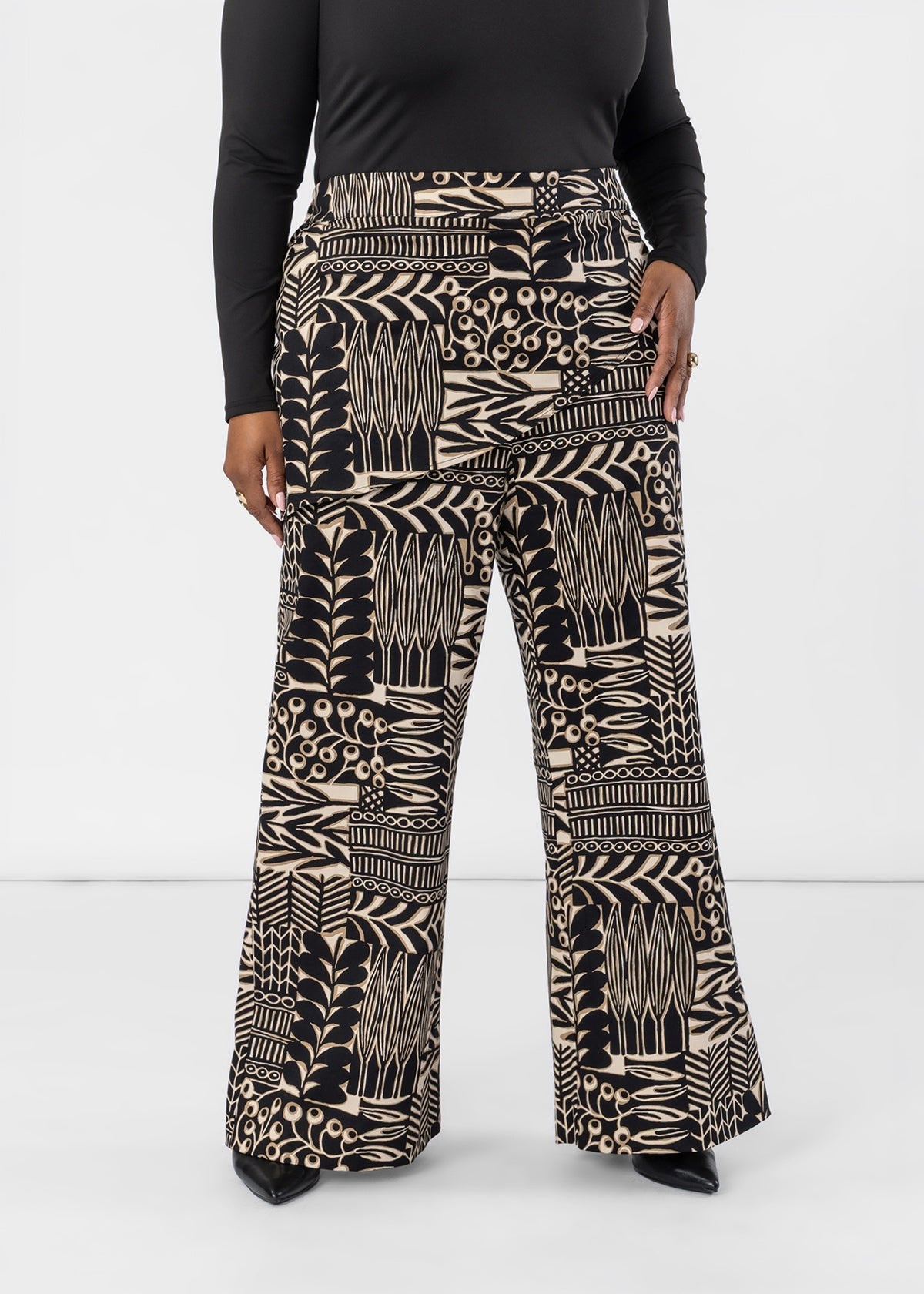 Front view of Yasmine women’s African print asymmetrical pants showing the ebony tan botanic pattern