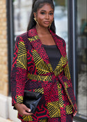 Woman wearing a colorful patterned suit outfit walking outdoors.