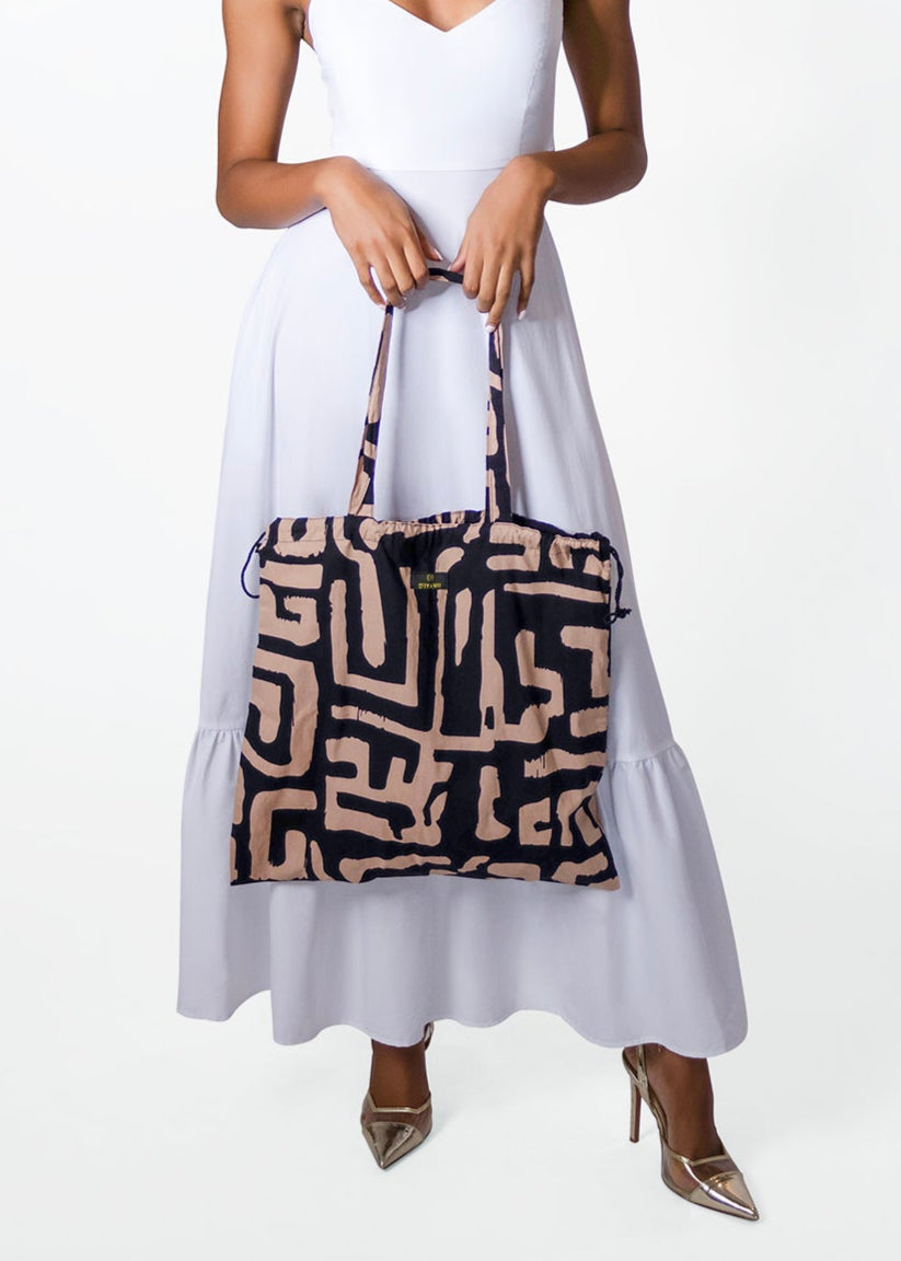 Woman holding a patterned bag against a white background