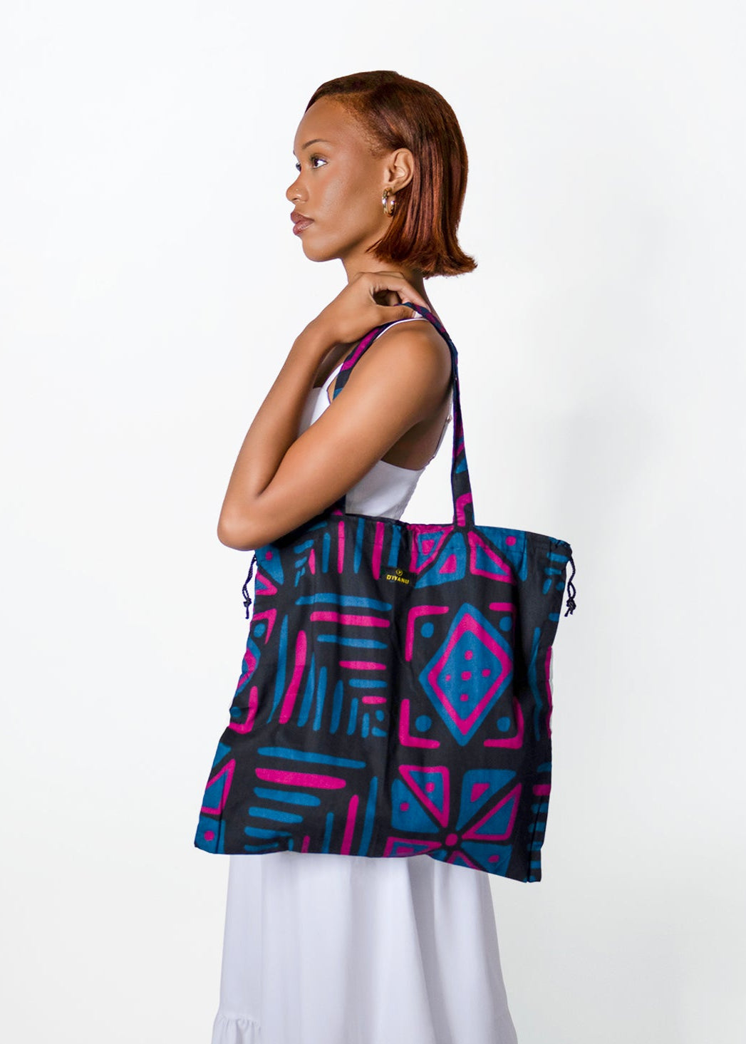 Woman carrying a colorful patterned tote bag on a white background