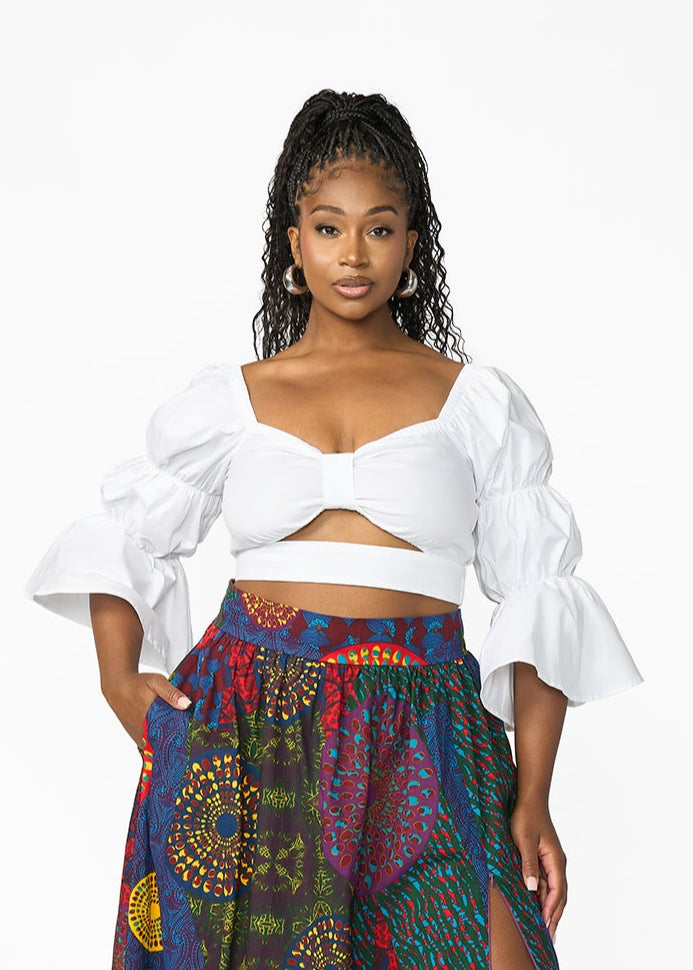 Woman wearing a white top and colorful patterned skirt on a white background