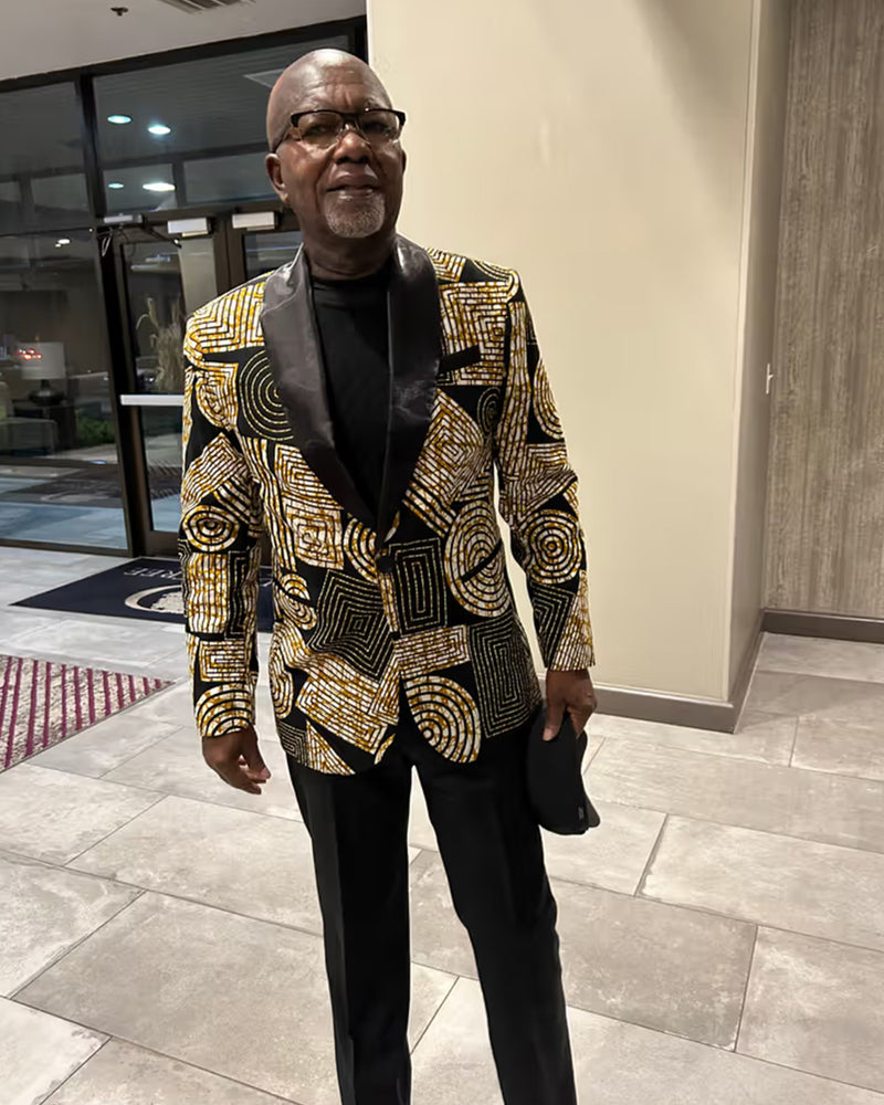 Front view of Rammy Men’s African Print Blazer Jacket showcasing a black and brown geometric pattern on a model indoors