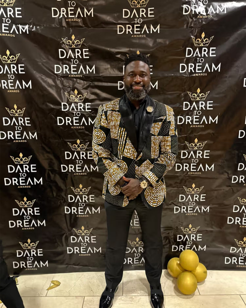 Front view of Rammy Men’s African Print Blazer Jacket showcasing a black and brown geometric pattern on a model at an awards event